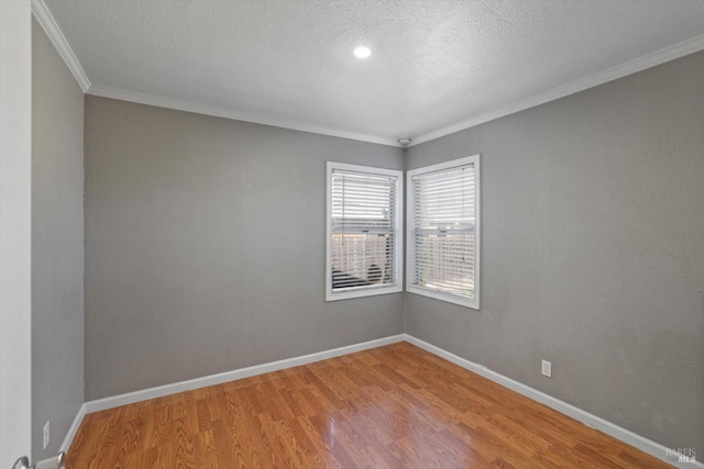 unfurnished room with wood-type flooring, ornamental molding, and a textured ceiling