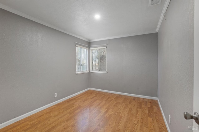 unfurnished room featuring crown molding and light wood-type flooring