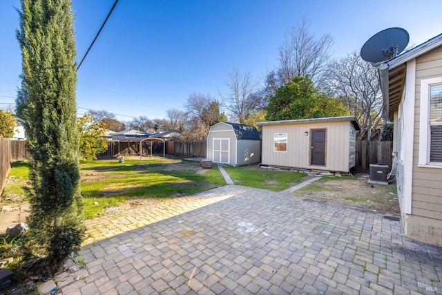 view of yard featuring a patio area, cooling unit, and a storage unit