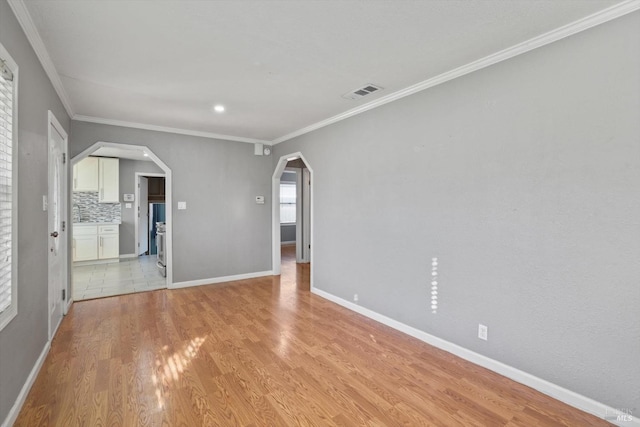 empty room with light wood-type flooring and ornamental molding