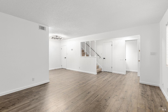 empty room featuring a textured ceiling and light wood-type flooring