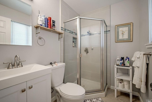 bathroom featuring vanity, a shower with shower door, toilet, and wood-type flooring