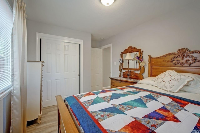 bedroom with light hardwood / wood-style floors and a closet