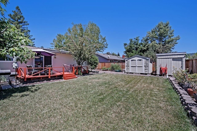 view of yard featuring a wooden deck and a storage unit