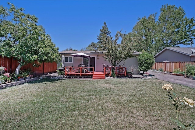 rear view of property with a lawn and a wooden deck