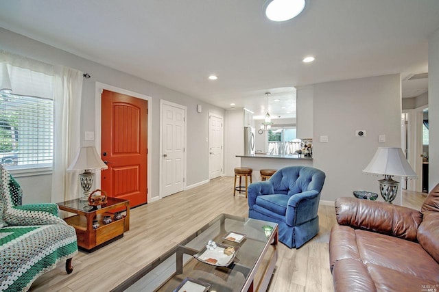 living room featuring a chandelier and light hardwood / wood-style floors