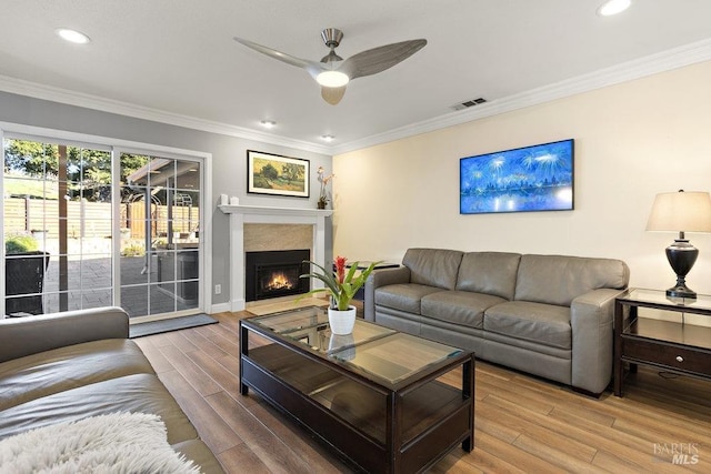 living room with wood-type flooring, ceiling fan, and ornamental molding