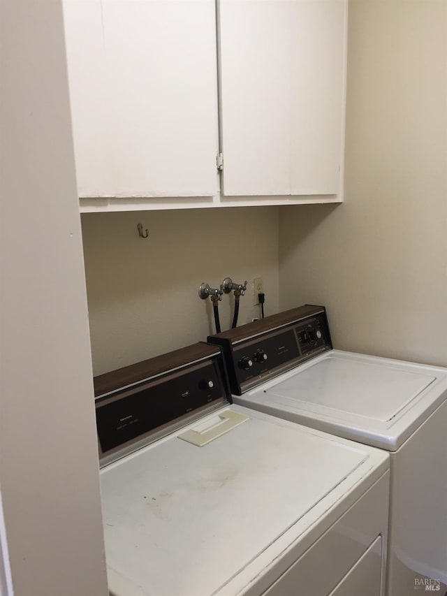 laundry room featuring cabinets and washing machine and clothes dryer