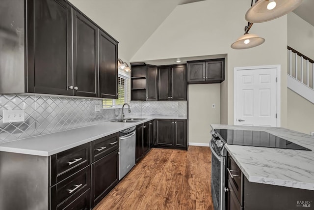 kitchen featuring sink, wood-type flooring, high vaulted ceiling, stainless steel appliances, and decorative backsplash