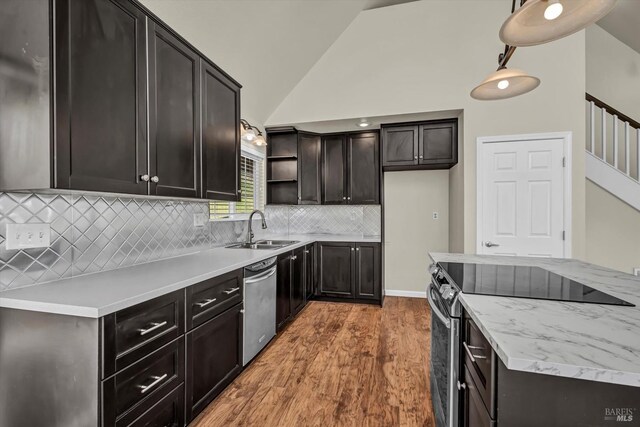 kitchen featuring pendant lighting, sink, hardwood / wood-style flooring, stainless steel appliances, and vaulted ceiling