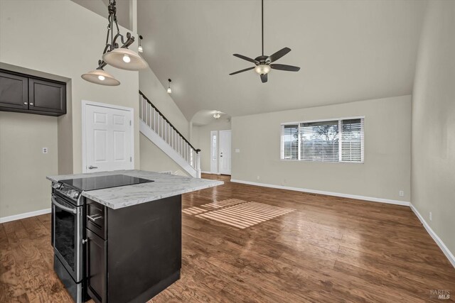 unfurnished living room with hardwood / wood-style flooring, high vaulted ceiling, and ceiling fan