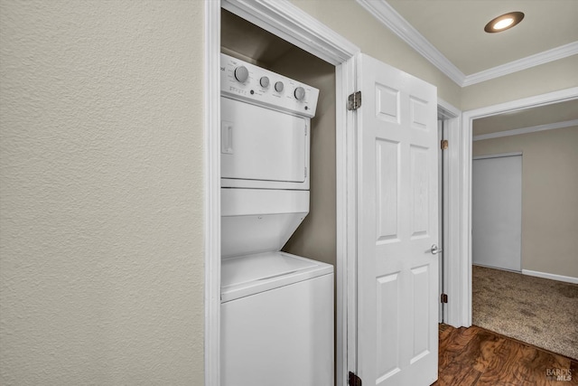 laundry room featuring crown molding, dark wood-type flooring, and stacked washer / dryer