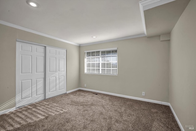 unfurnished bedroom with ornamental molding, a closet, and carpet