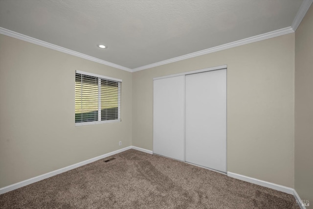 unfurnished bedroom with ornamental molding, carpet, and a closet