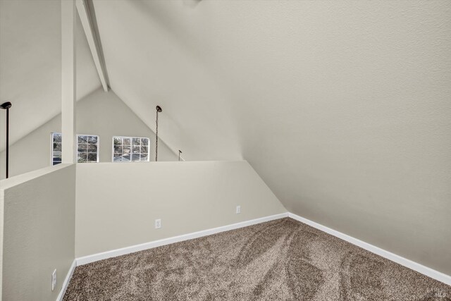 additional living space with lofted ceiling with beams, ceiling fan, carpet floors, and a textured ceiling