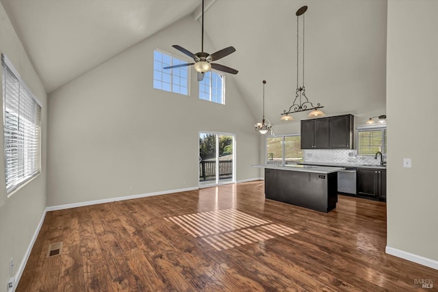 kitchen with a breakfast bar, hanging light fixtures, dark hardwood / wood-style floors, dishwasher, and backsplash