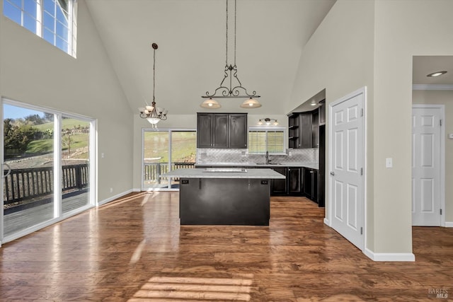 kitchen featuring sink, a center island, hanging light fixtures, a healthy amount of sunlight, and backsplash