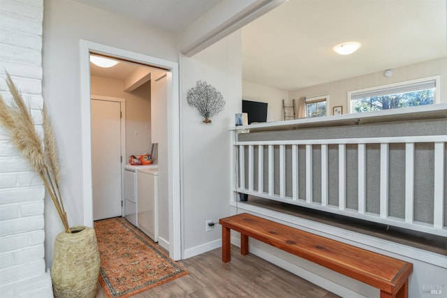 hall featuring wood-type flooring and separate washer and dryer