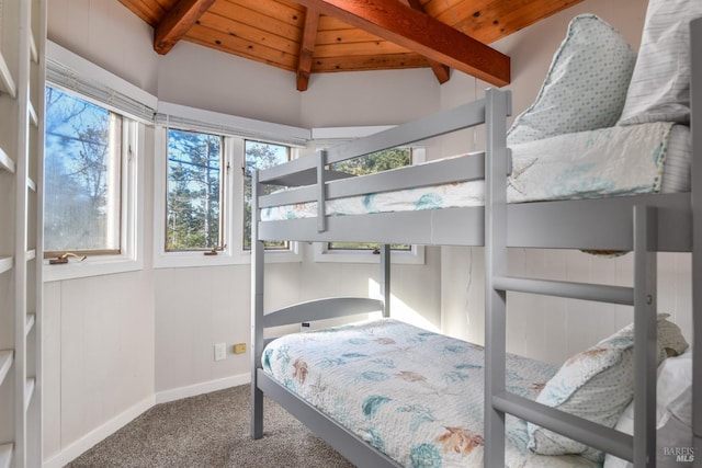 carpeted bedroom featuring baseboards, wood ceiling, and vaulted ceiling with beams