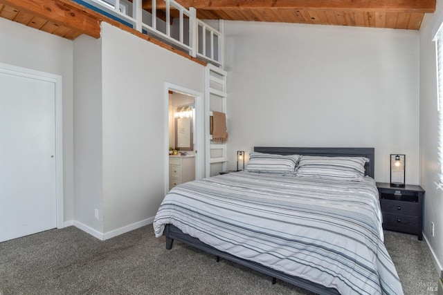 carpeted bedroom with beamed ceiling, ensuite bathroom, and wooden ceiling