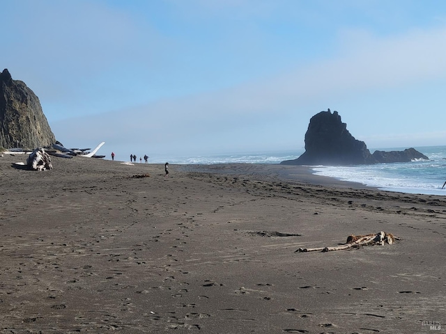 view of mountain feature with a view of the beach and a water view