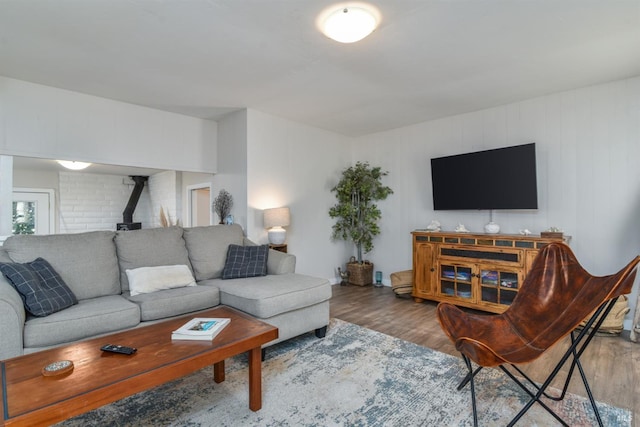 living room with a wood stove and wood finished floors