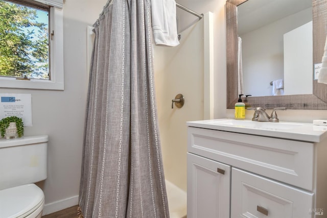 bathroom with vanity, toilet, a shower with curtain, and baseboards