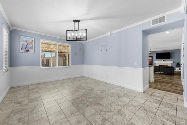 spare room featuring crown molding and a notable chandelier