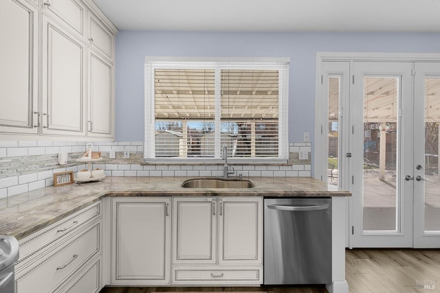 kitchen featuring sink, stainless steel dishwasher, white cabinetry, and french doors