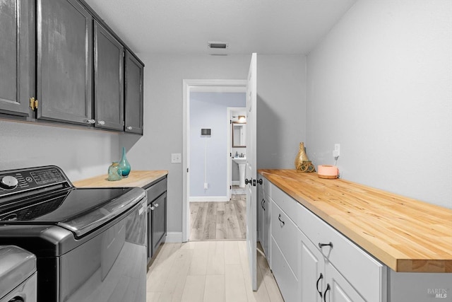 washroom featuring cabinets and washing machine and dryer