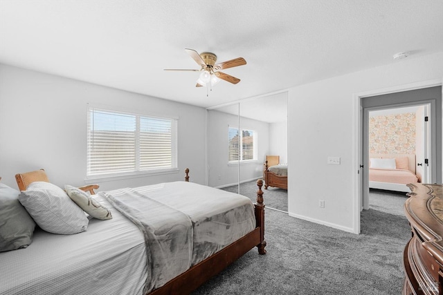 bedroom with ceiling fan, dark carpet, and a closet