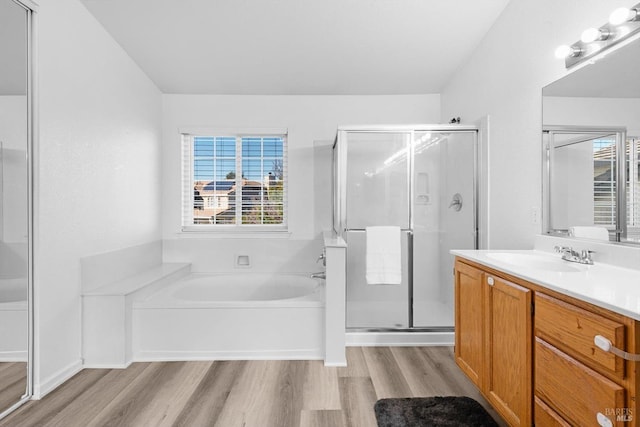 bathroom featuring wood-type flooring, plus walk in shower, and vanity