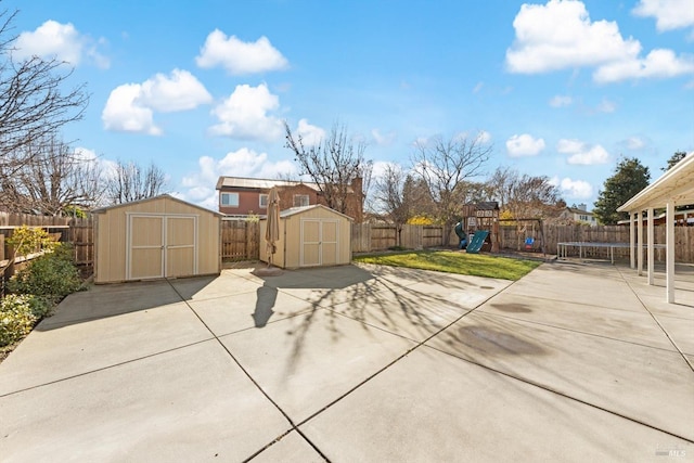 view of patio with a playground and a shed