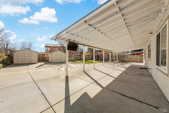 view of patio / terrace featuring a playground and a storage shed