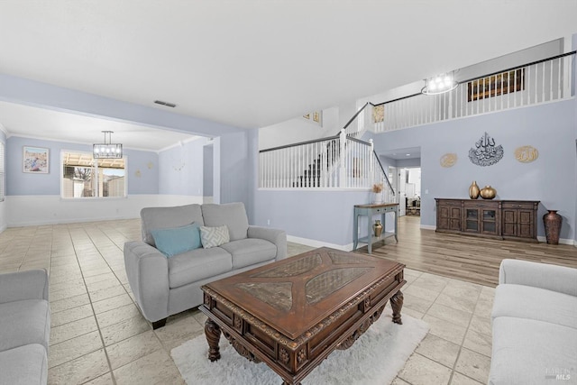 living room with crown molding and a chandelier