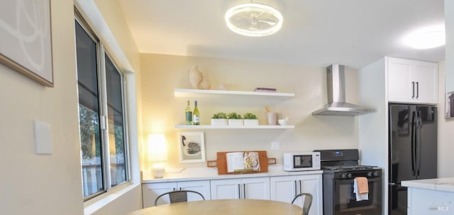 kitchen with white cabinets, wall chimney exhaust hood, and black appliances