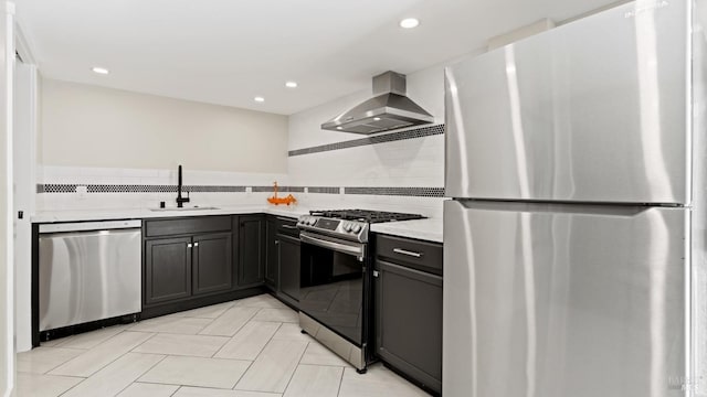 kitchen with appliances with stainless steel finishes, wall chimney exhaust hood, sink, tasteful backsplash, and light tile patterned floors