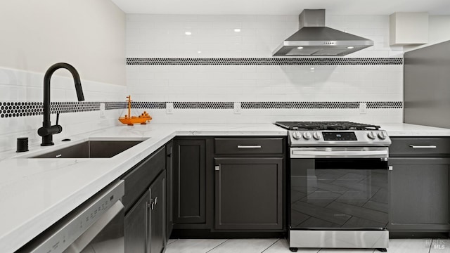 kitchen featuring light stone countertops, sink, dishwashing machine, stainless steel gas range oven, and wall chimney exhaust hood