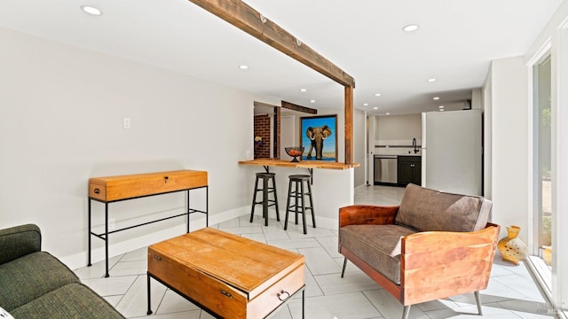 living room featuring sink, beam ceiling, and light tile patterned floors