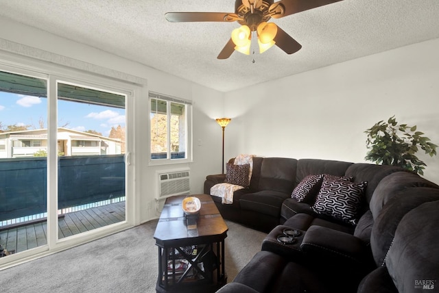 living room with ceiling fan, a textured ceiling, carpet, and a wall unit AC