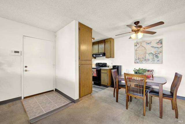 carpeted dining room with a textured ceiling and ceiling fan