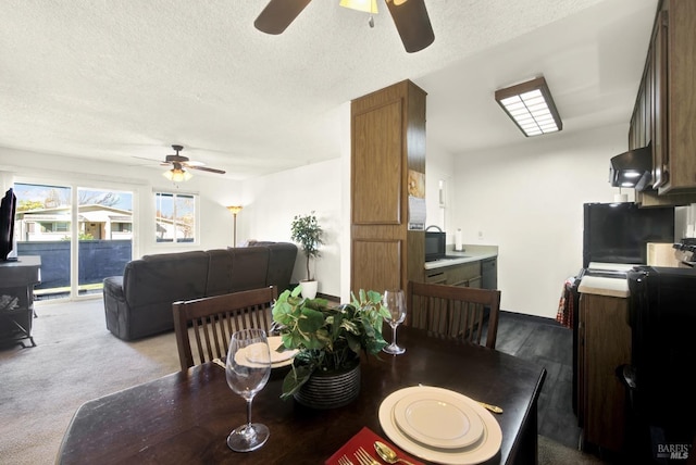 carpeted dining room with ceiling fan and a textured ceiling