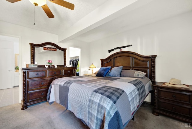 carpeted bedroom featuring ceiling fan, beam ceiling, a textured ceiling, a spacious closet, and a closet