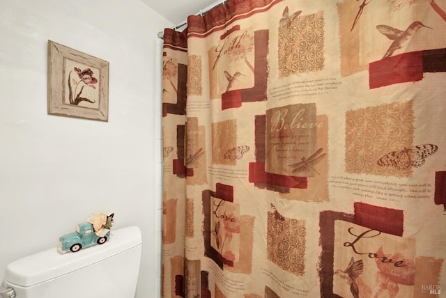 bathroom with curtained shower and toilet