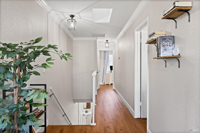 corridor featuring ornamental molding, a skylight, and wood-type flooring