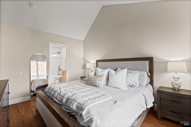 bedroom featuring ensuite bath, vaulted ceiling, and dark hardwood / wood-style floors