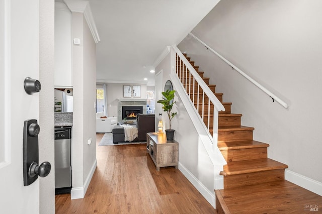 staircase featuring hardwood / wood-style flooring and ornamental molding