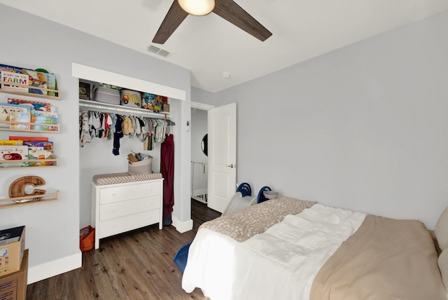 bedroom with dark wood-type flooring, ceiling fan, and a closet