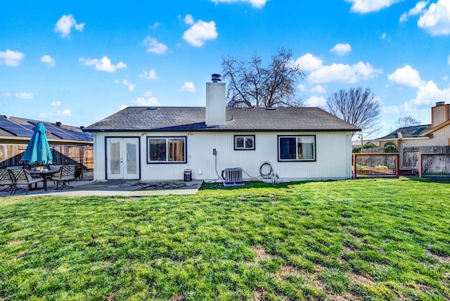 back of property with a yard, a patio area, and french doors