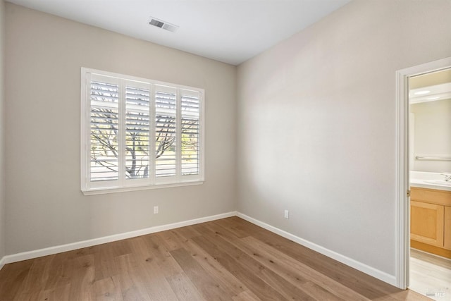 unfurnished room with sink and light wood-type flooring